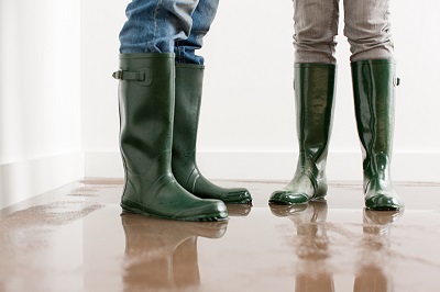 people in boots in flooded house